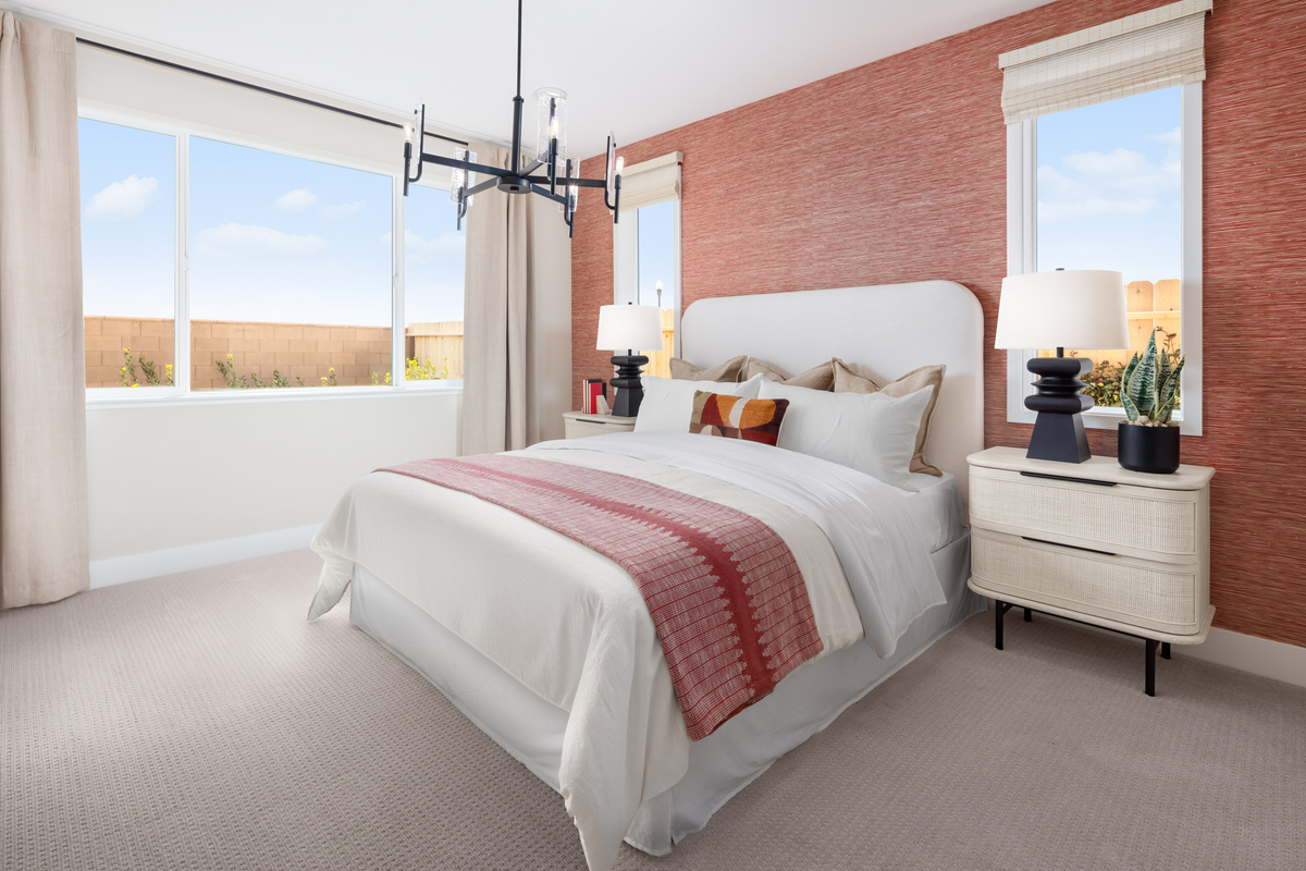 bedroom with burnt orange wallpaper and windows