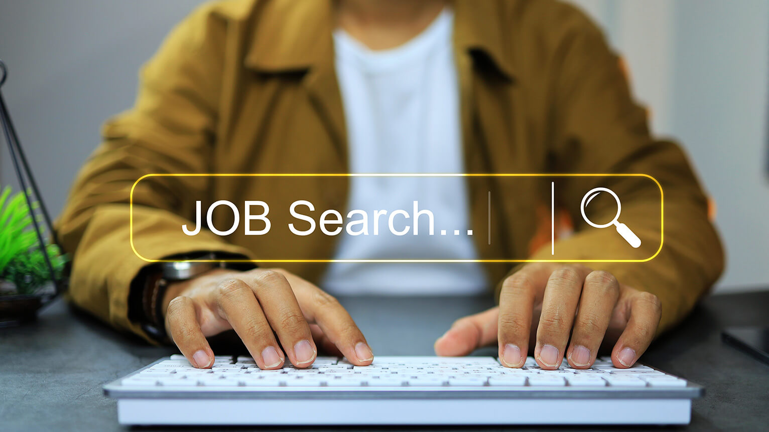 Image of a person typing on a keyboard for a job search. 