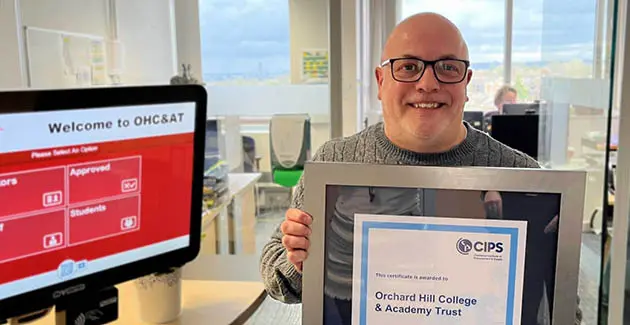 Geoff Hopper holding a framed CIPS certificate for Orchard Hill College & Academy Trust