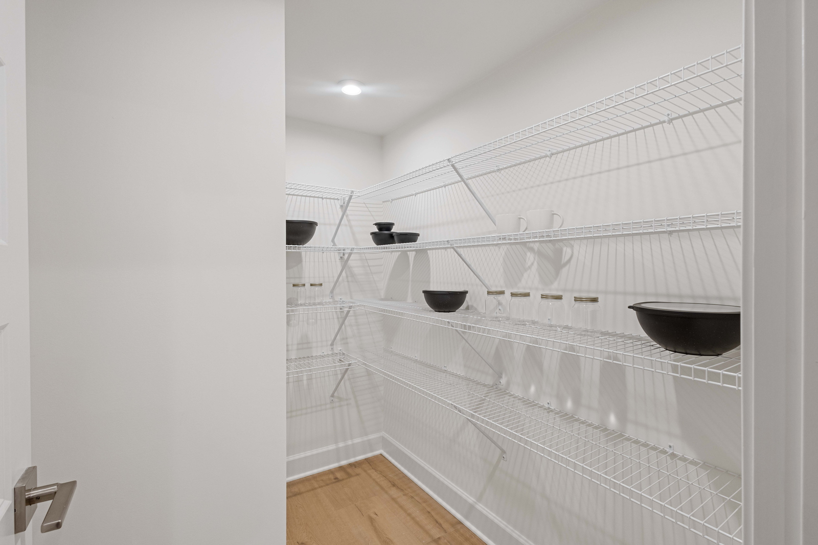large walk-in pantry with built in wire shelves