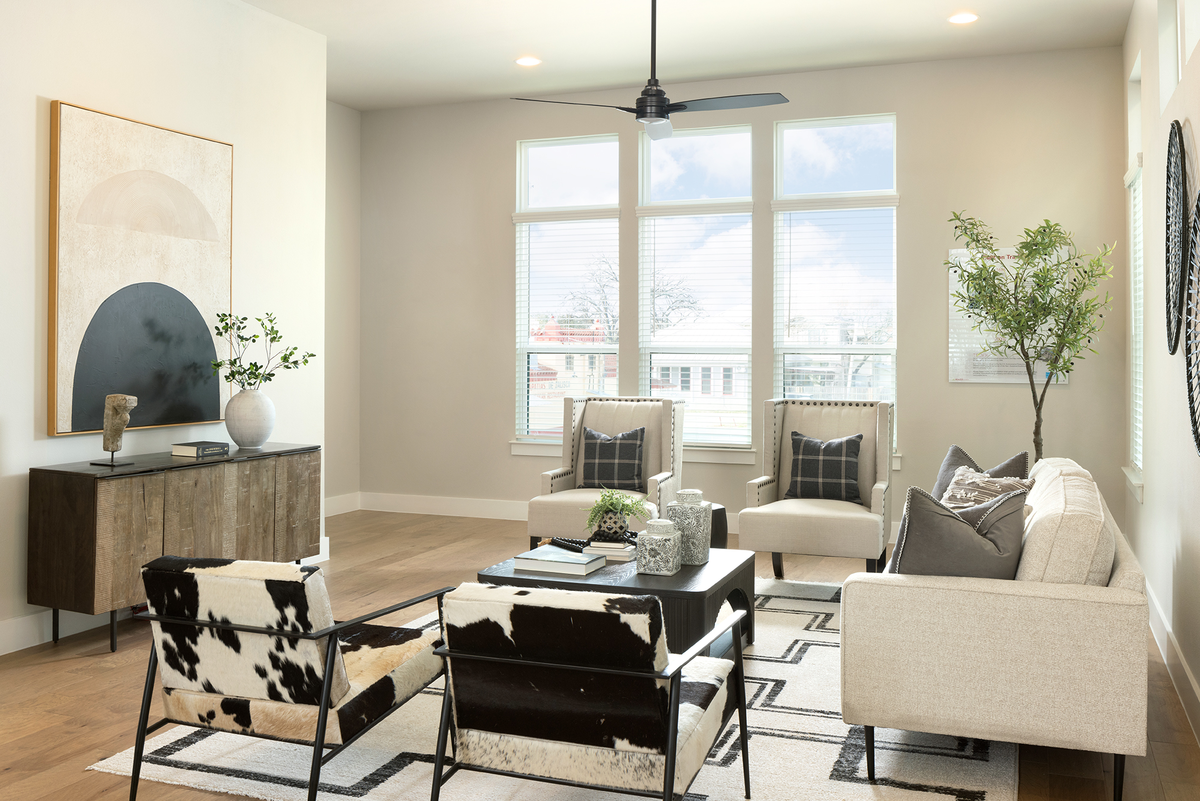 living room with brown flooring, couches & windows