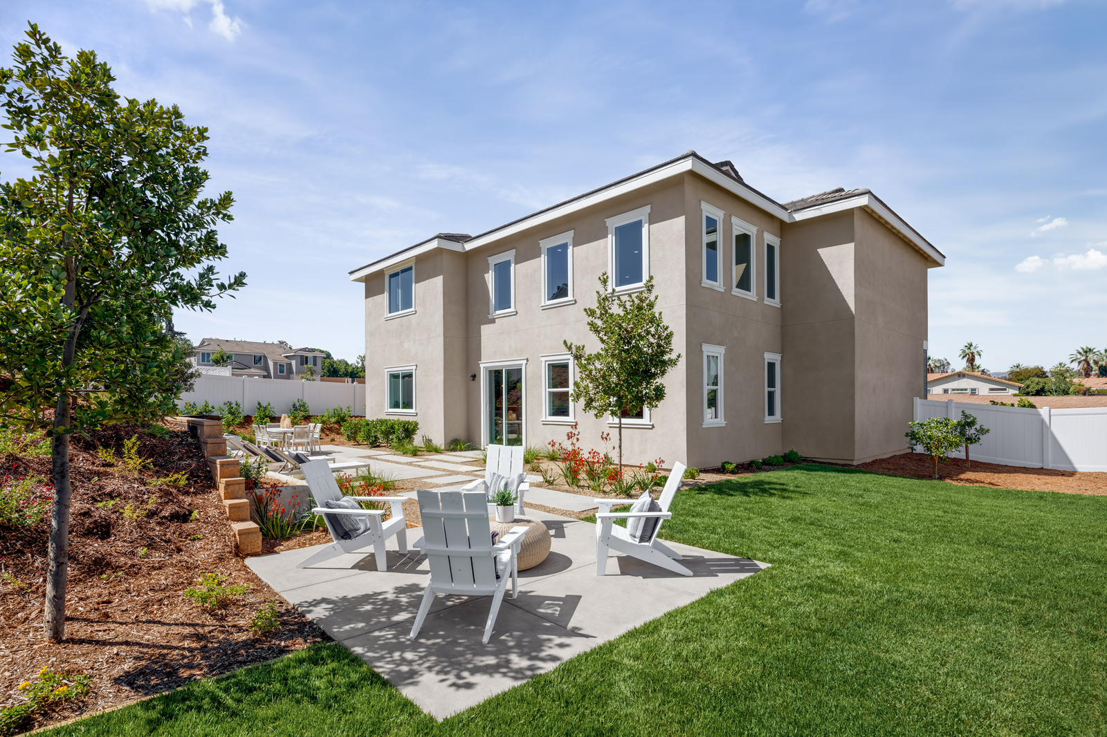 A landscaped back yard of a 2-story home