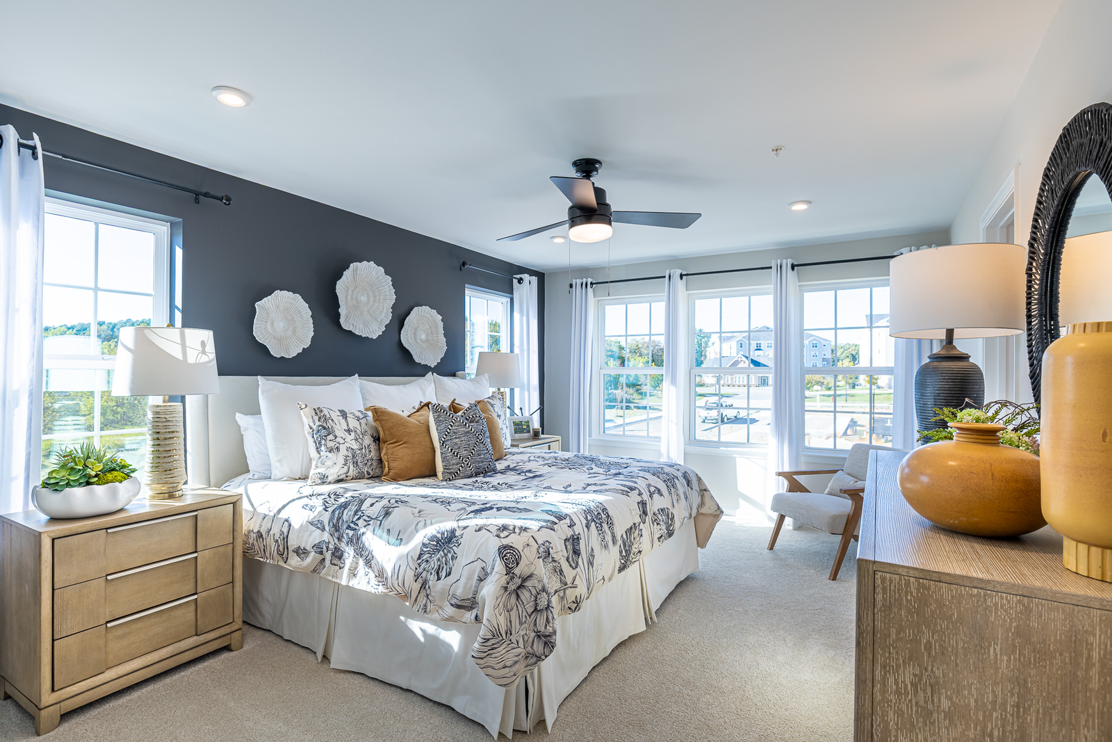 primary suite with a king sized bed and multiple large windows