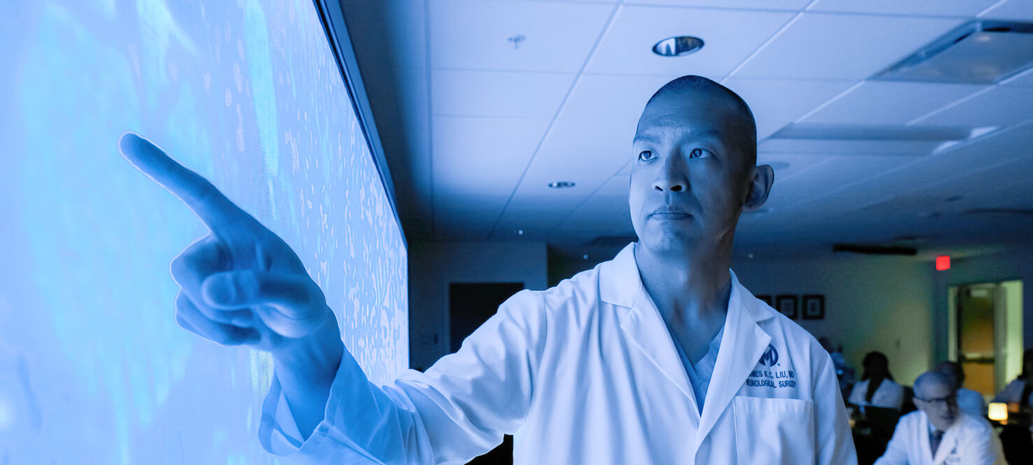 Dr. James Liu points to cancer cells during a tumor board