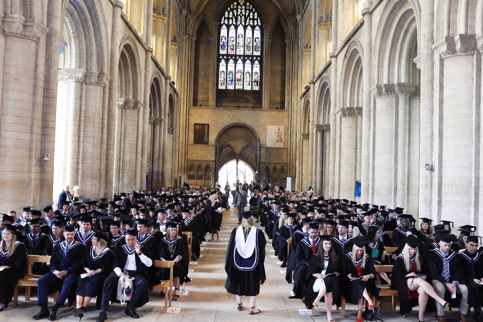 Long view of graduates seated inside the cathedral nave