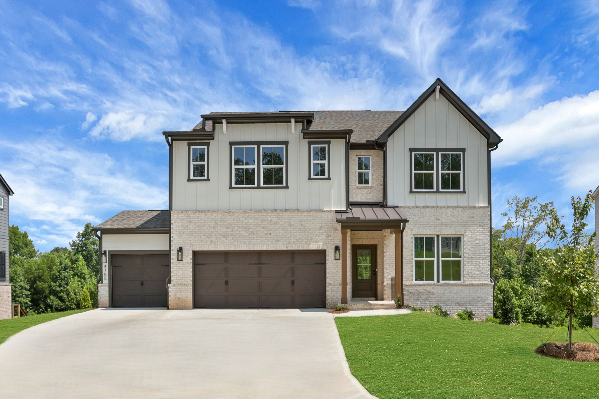 front of 2-story home with 3-car garage and light brick