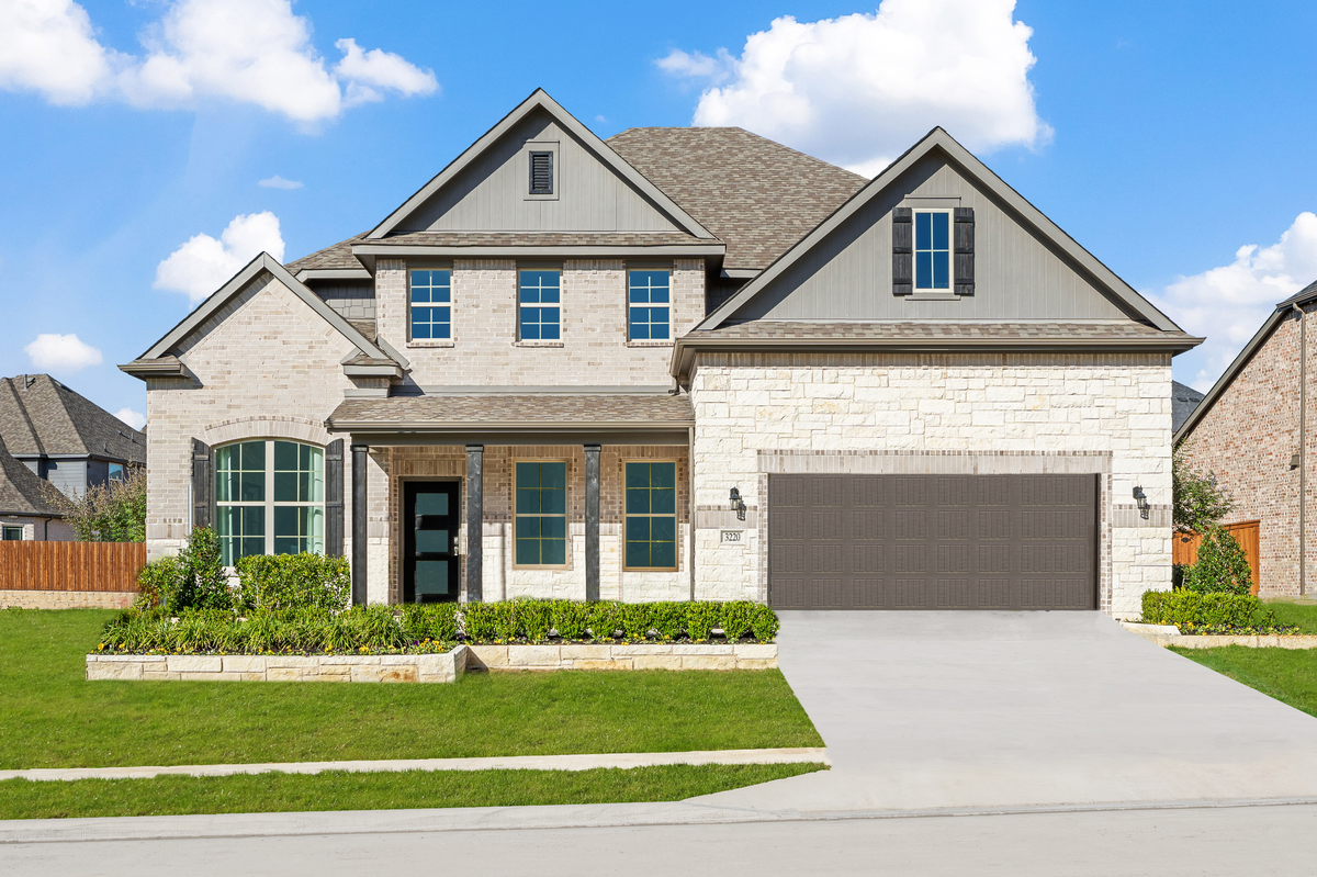 brick and stone exterior with tree in front yard