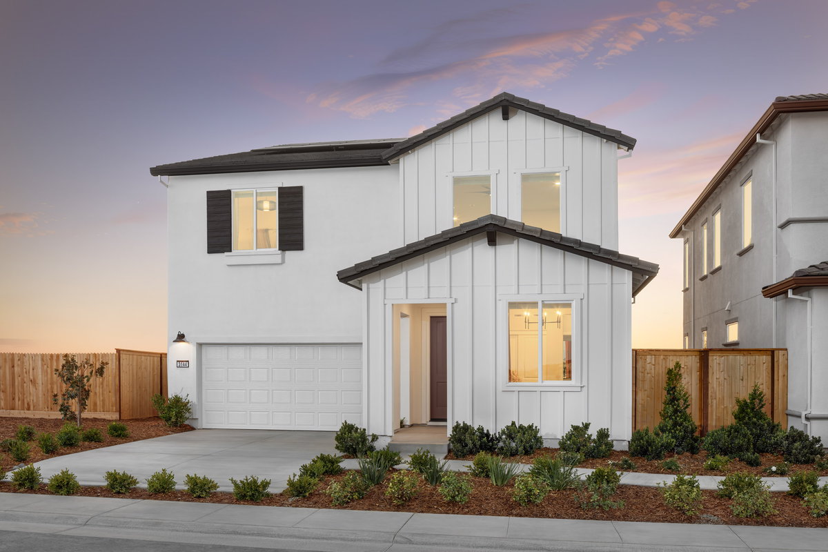 white farmhouse style home with brown front door