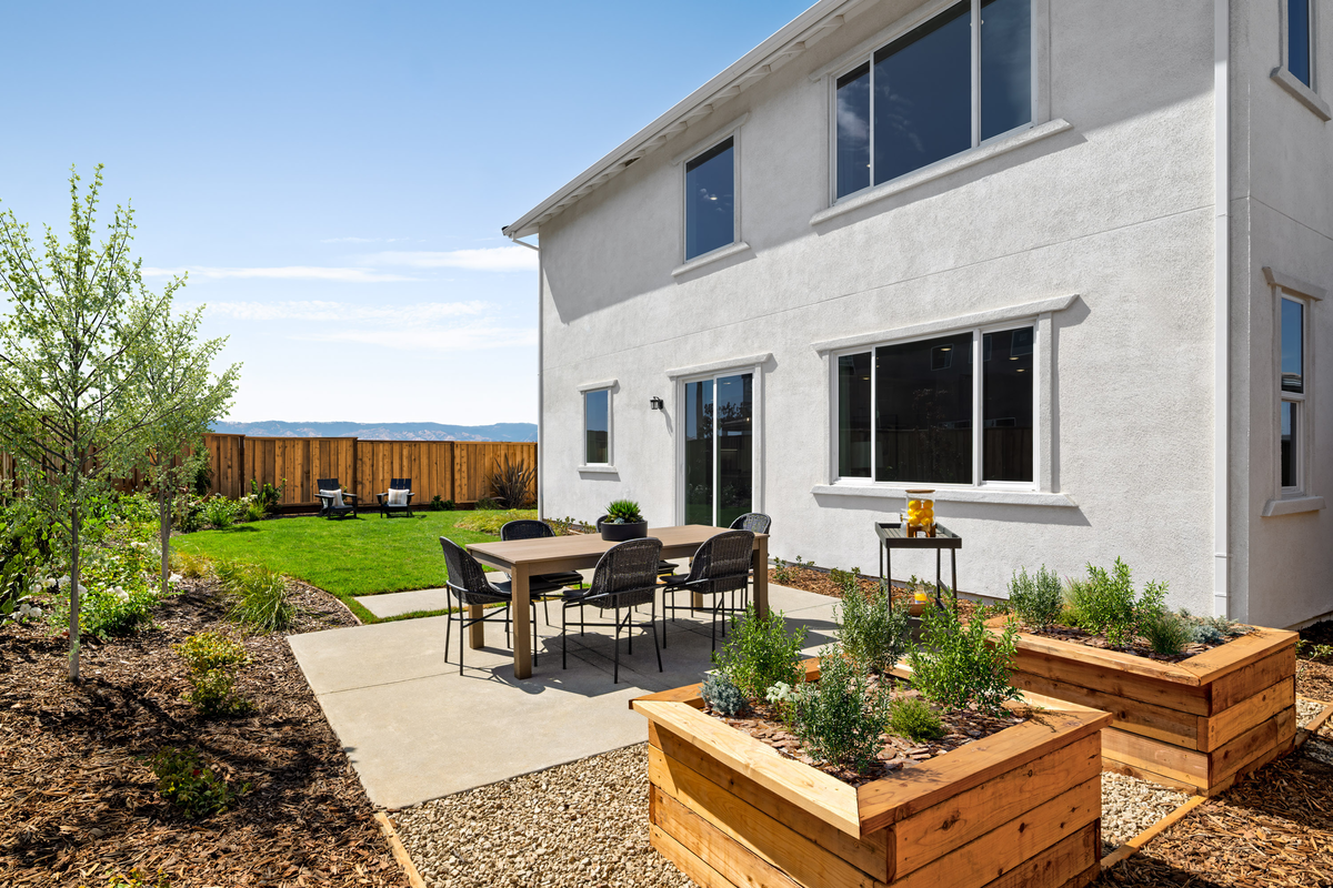 backyard with grassy area & garden beds