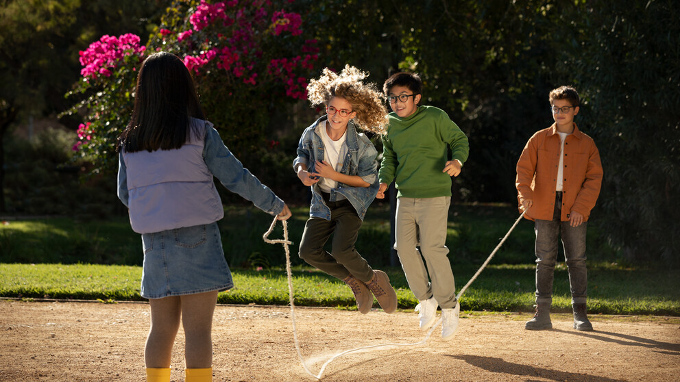 Four children playing outside while wearing glasses