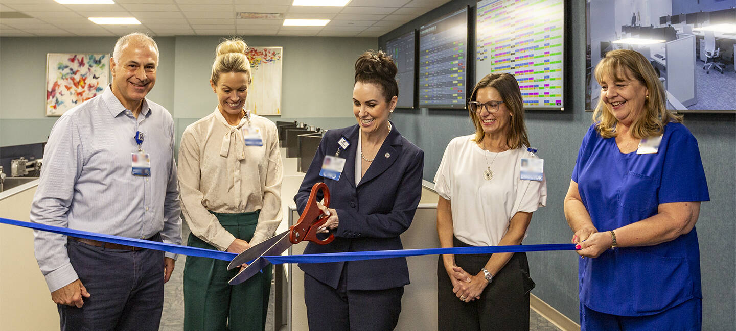 Chief Nursing Officer Kelley Gonzalvo, DNP, cuts the ribbon on the new Mission Control Center with, from left, Michael Gonzalez, Miki Williams, Catie Wiernasz and Marina Rivers.
