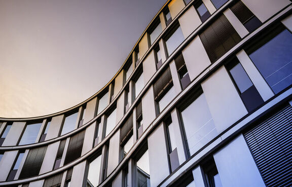Modern glass building against a sunset sky