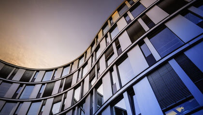 Modern glass building against a sunset sky