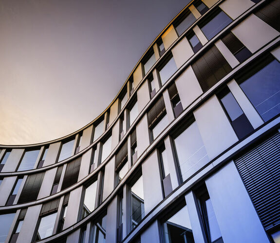 Modern glass building against a sunset sky