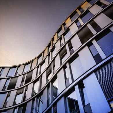 Modern glass building against a sunset sky