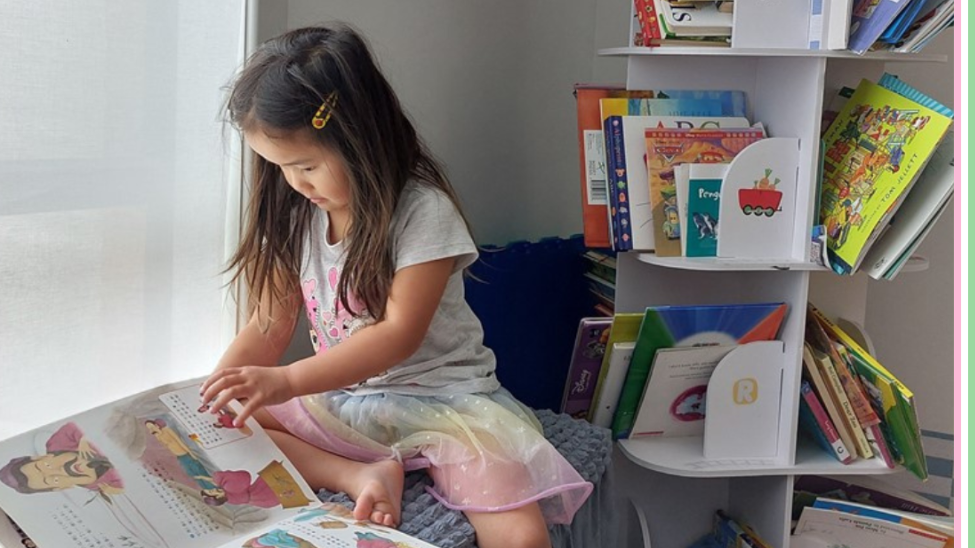 A young female child sit on her bend reading a picture book 
