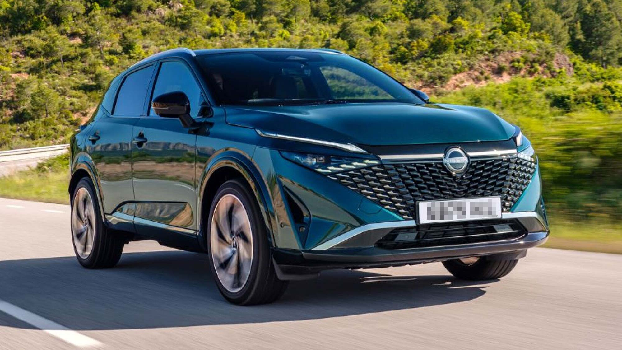 Dark green Nissan Qashqai SUV driving on a road, shown from the front left with trees and hills behind.