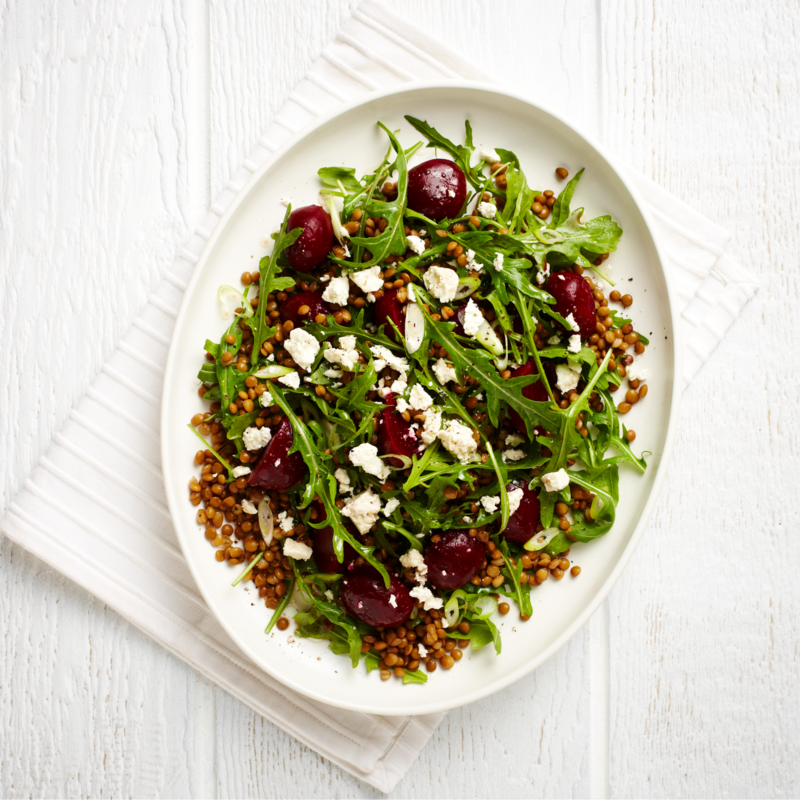 Nutrition Australia's Beetroot, Lentil and Feta Salad served on a white plate, placed on a white table.