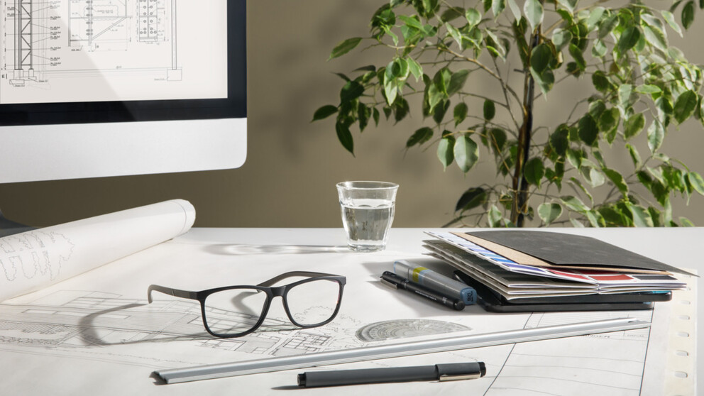 Architect's workspace featuring a pair of glasses with HOYA occupational lenses