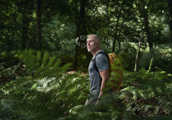 Man with backpack walking in forest, a halo of lenses around his head
