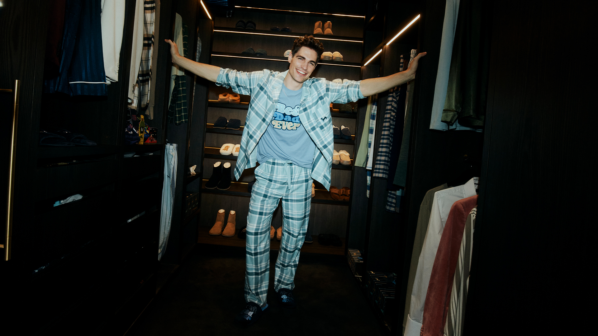 Man wearing Peter Alexander Father's Day pyjamas and slippers standing in a wardrobe