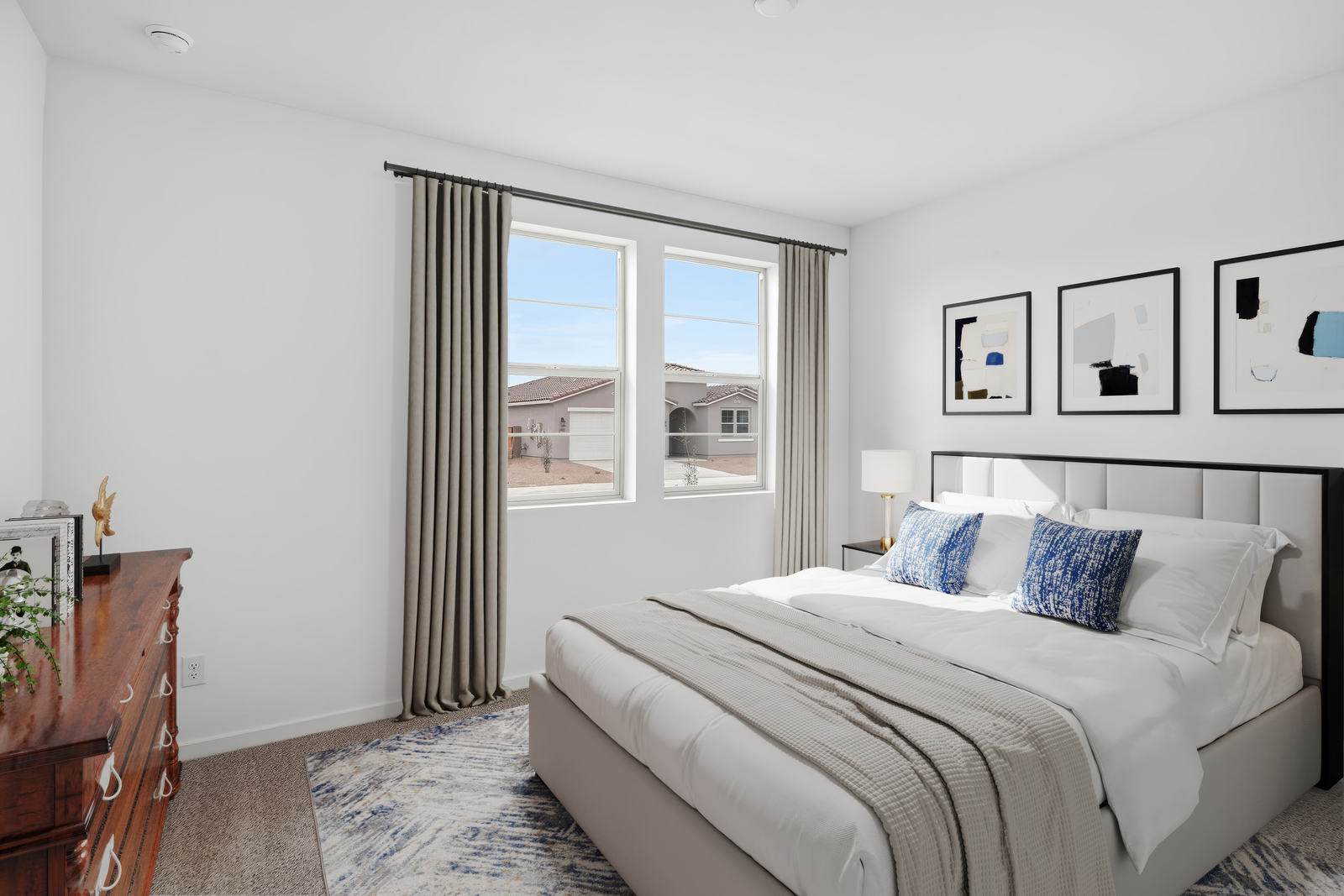 bedroom with a large bed, blue accent colors and a large brown dresser