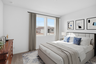 bedroom with a large bed, blue accent colors and a large brown dresser