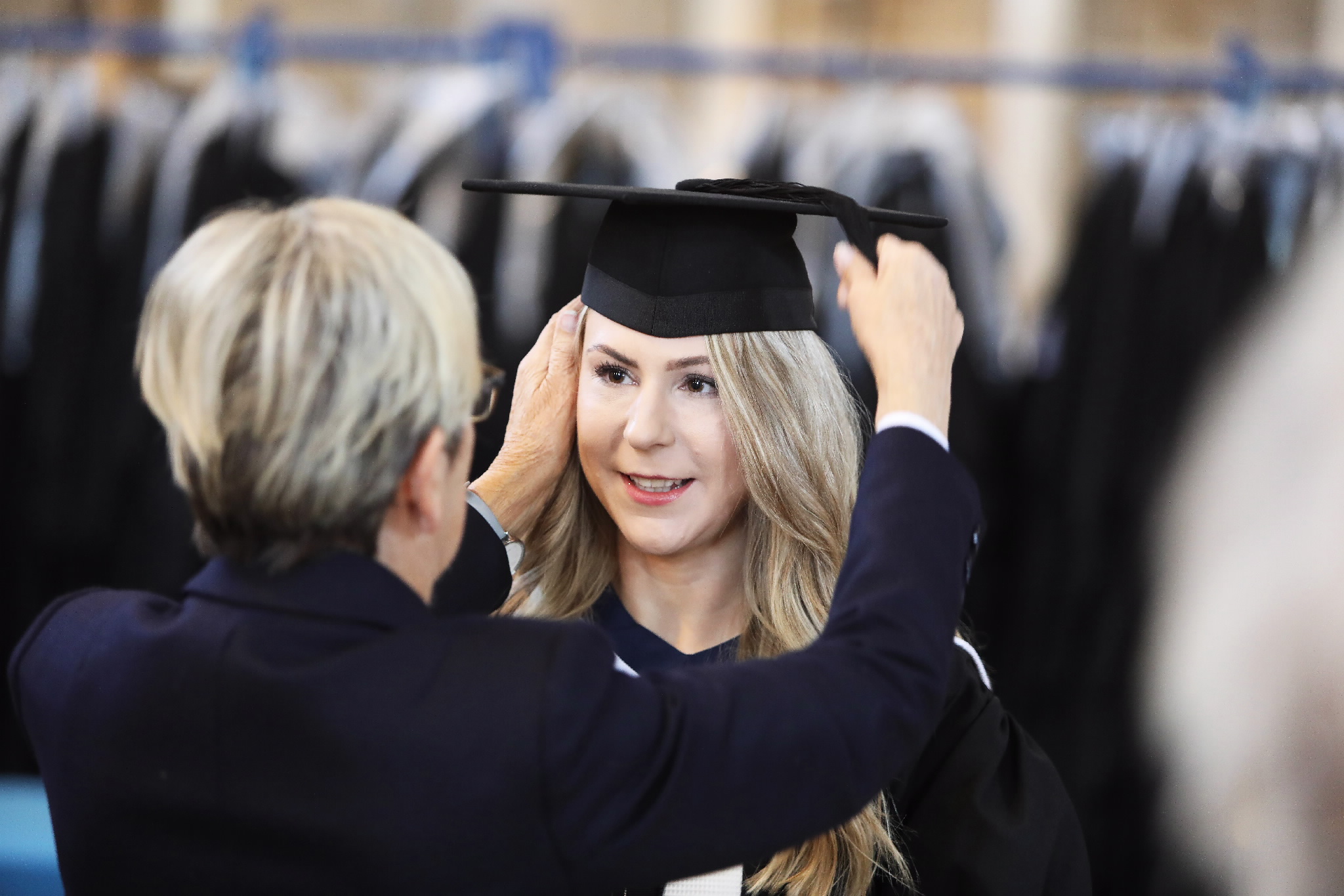 Person adjusting a graduate's cap before the ceremony