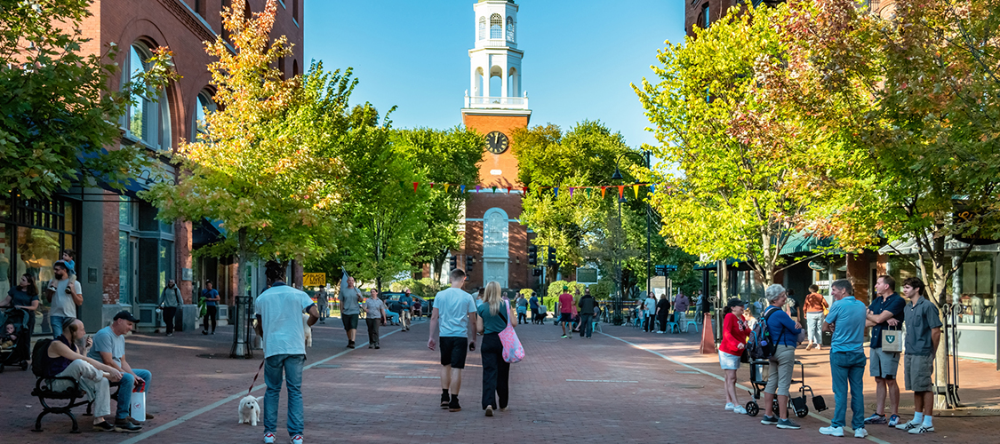 People walking in a busy plaza in South Burlington, Vt.