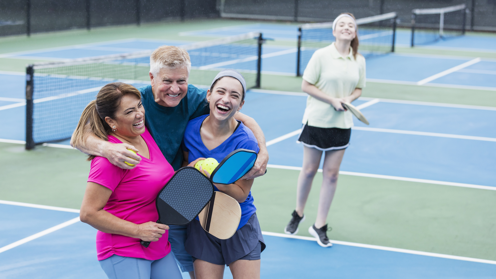 pickleball courts with a family hugging on them