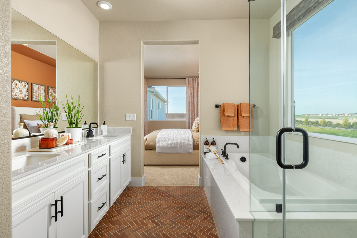 bathroom with white cabinets, and brick floor