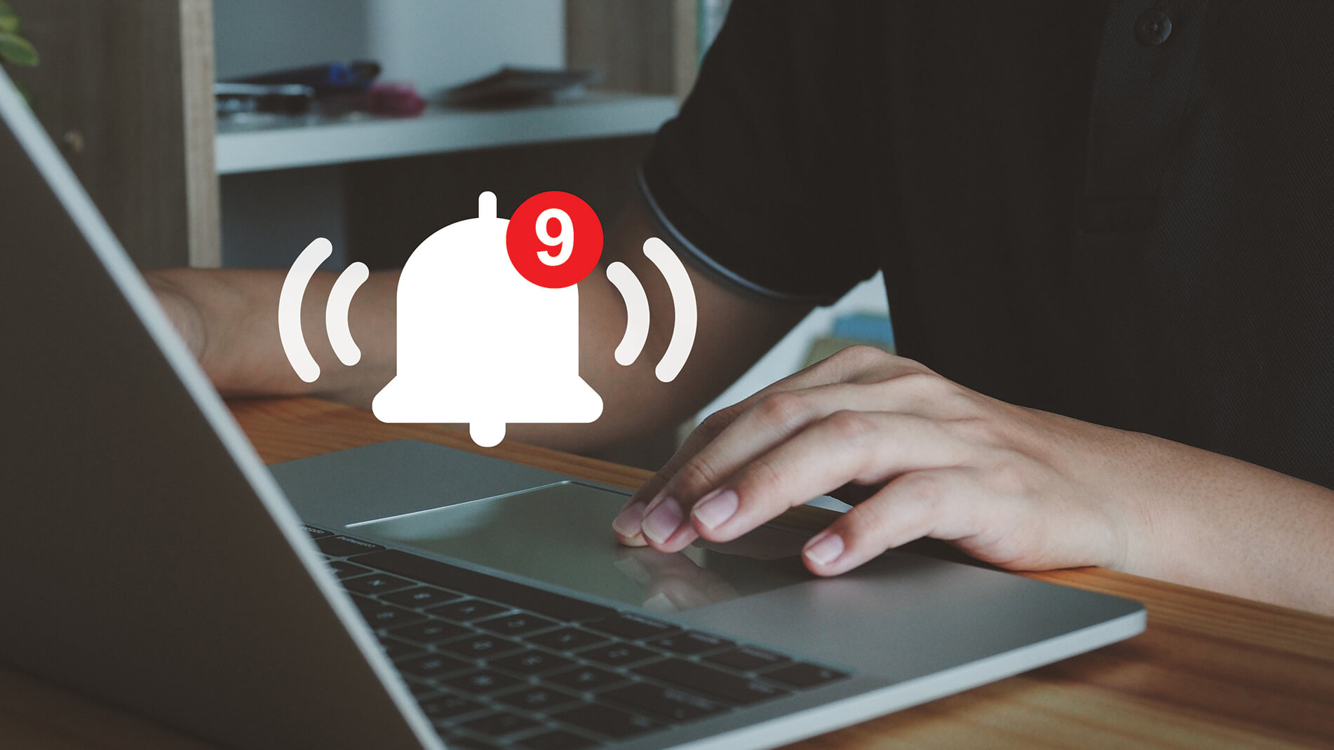 ProactiveAlerts.jpg Image of a person typing on a laptop computer with icon of notification bell.