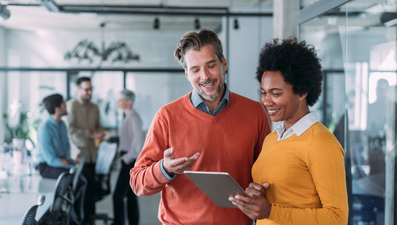 Casual business man and woman working on tablet
