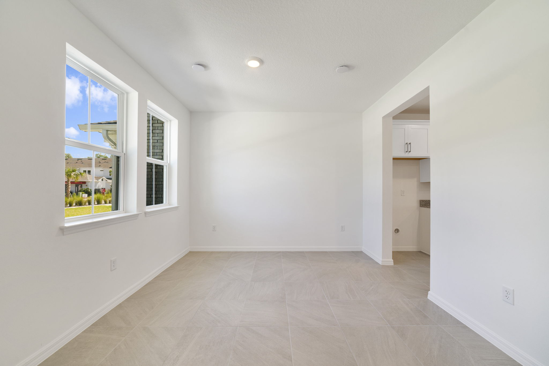 room with large windows and access to the foyer