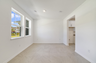 room with large windows and access to the foyer