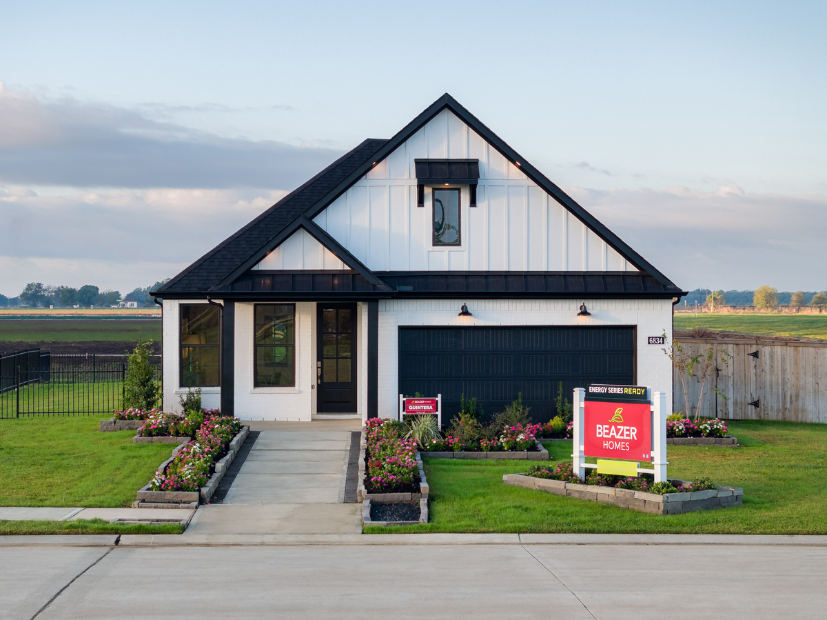 home exterior with white brick and landscaping 