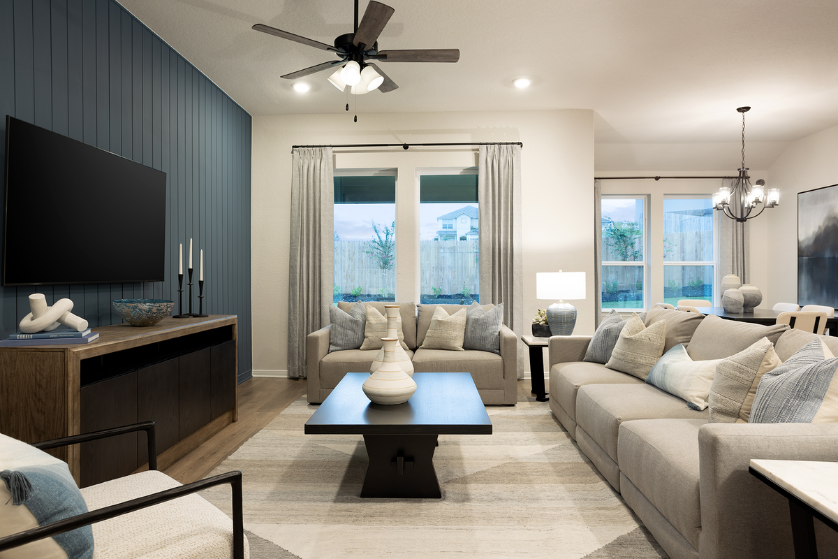 living room with a rug, couches & a ceiling fan