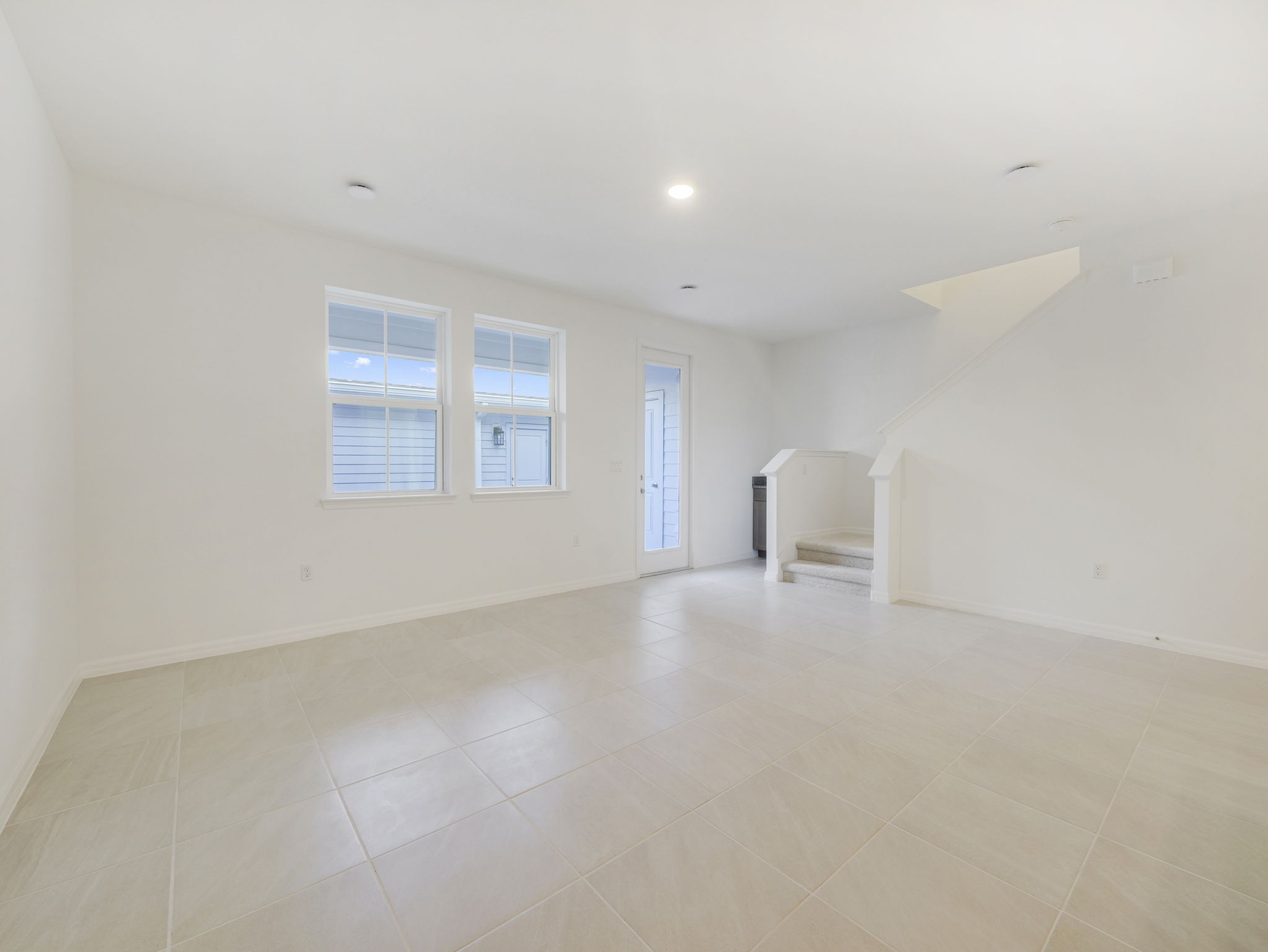 great room with tile flooring and two windows