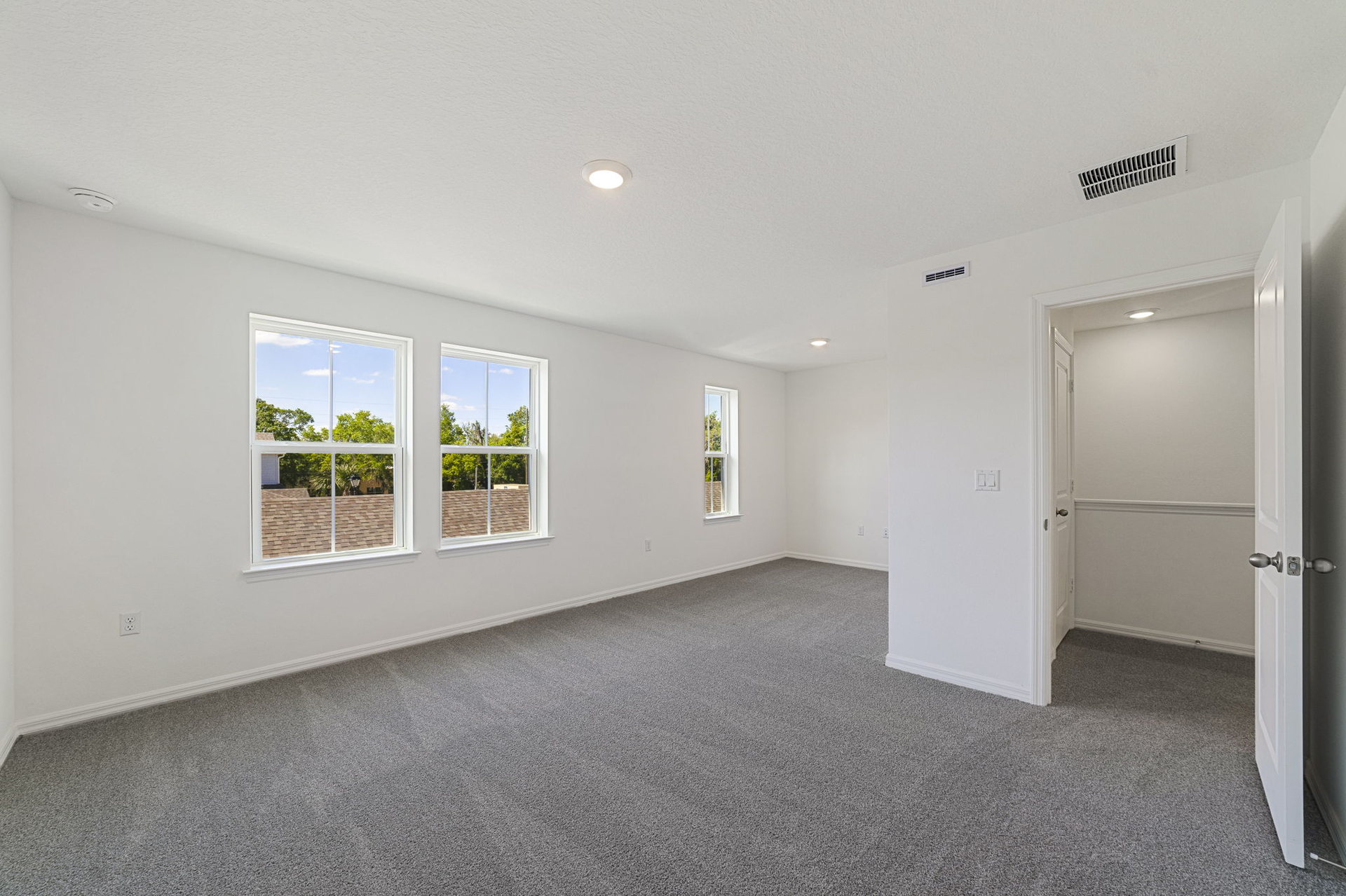 carpet throughout with a sitting room with large windows 
