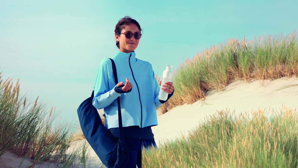 Sporty looking woman in the dunes wearing HOYA Sensity Dark sunglasses