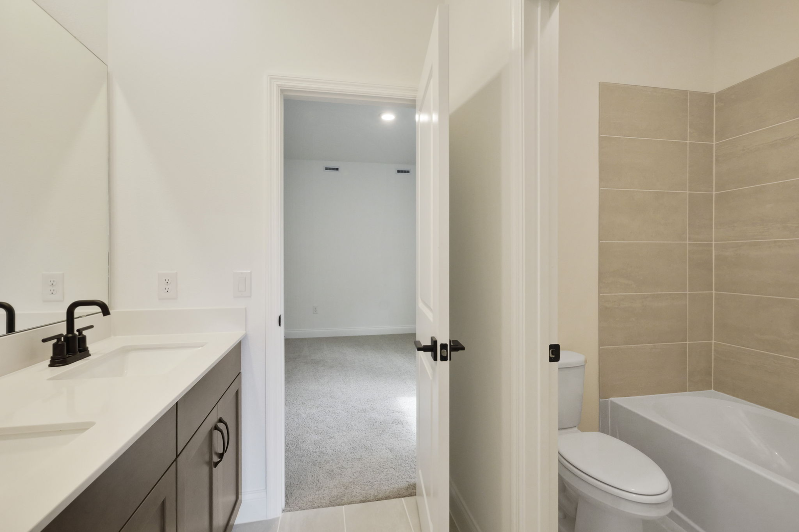 dual sink vanity, water closet, and shower