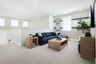 loft with navy blue sofa, light wood tables, multiple windows, and plant in corner