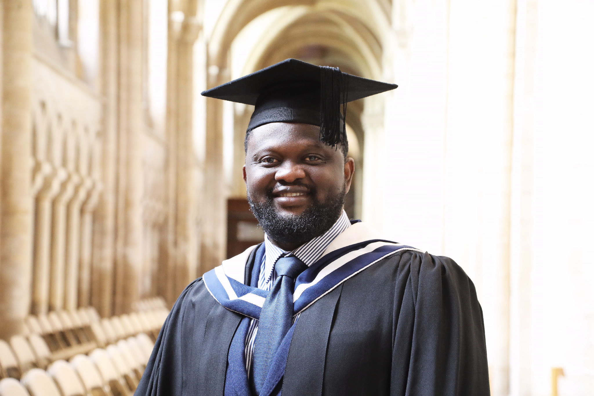 Smiling male graduate standing in the cathedral hallway