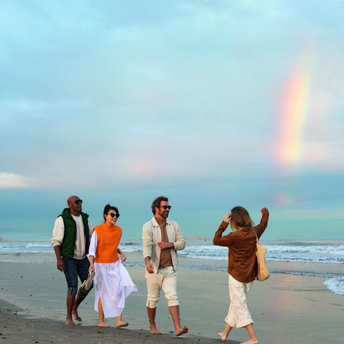 Gruppe fröhlicher Menschen mit Sonnenbrille am Strand
