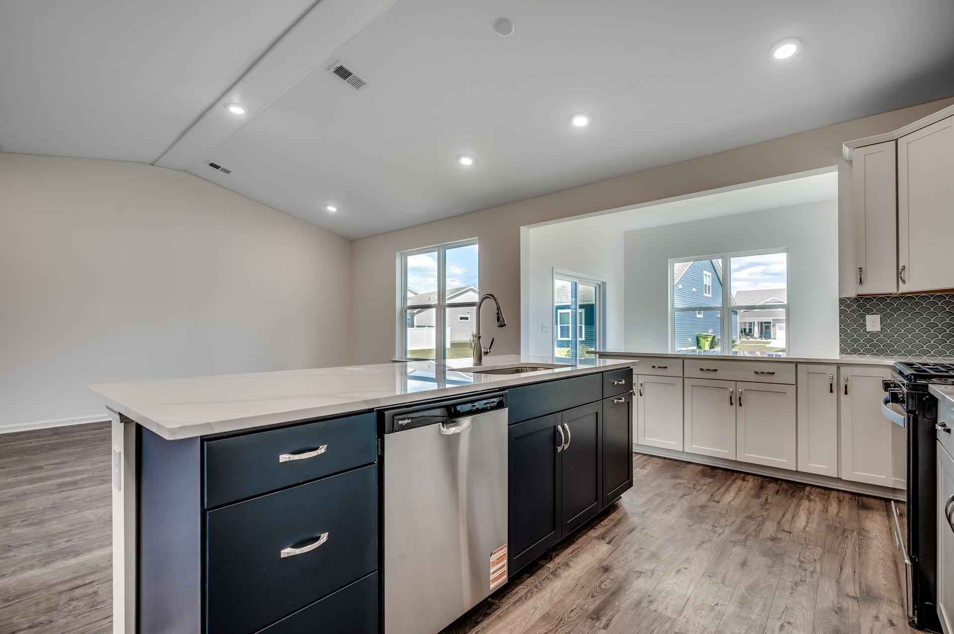 bright white cabinets with large island, bright white counter and backsplash