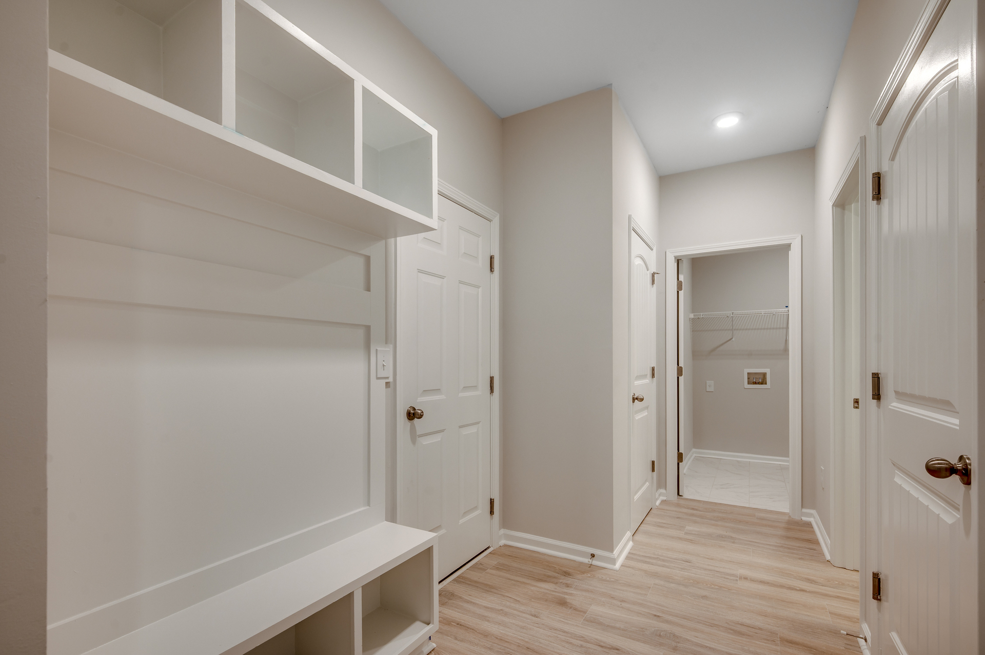 bright white built in shelving with bench for storage
