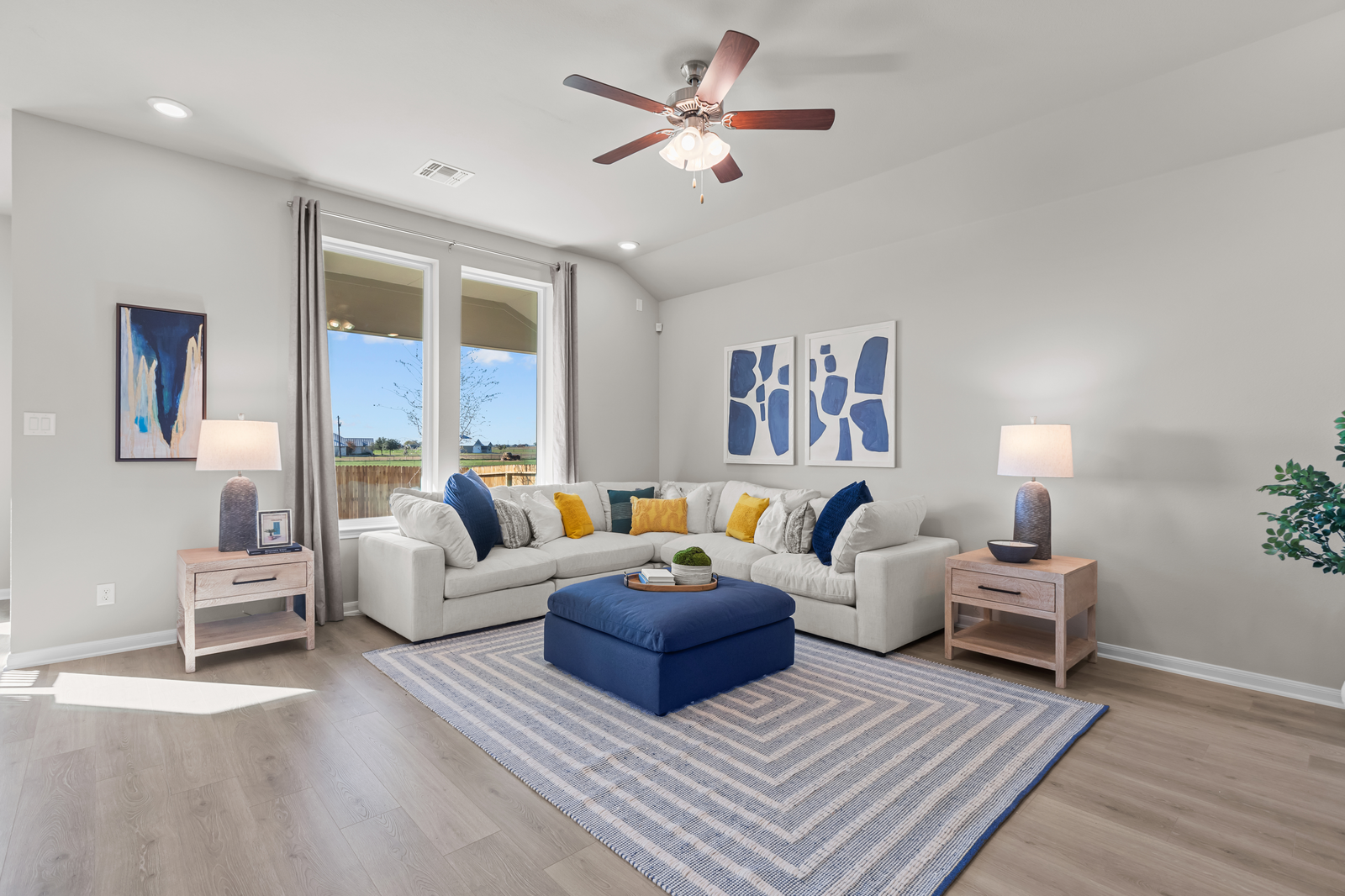 great room with brown flooring, rug & couches 