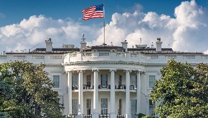 Front view of the White House with a U.S. waving on top of the building