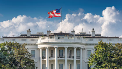 Front view of the White House with a U.S. waving on top of the building