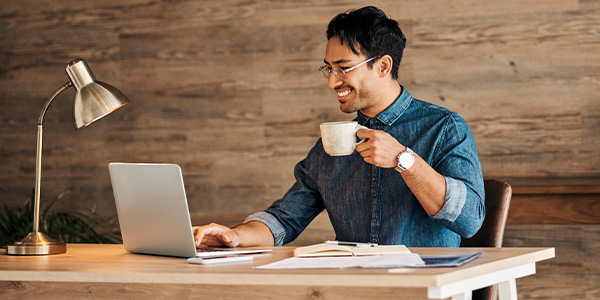 A man drinking coffee at a desk